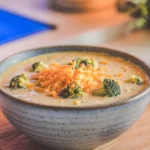 A creamy bowl of broccoli cheddar soup with cheese and broccoli florets – how to make broccoli cheddar soup thicker.