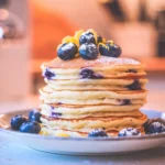 Fluffy lemon blueberry ricotta pancakes served with fresh blueberries and lemon zest